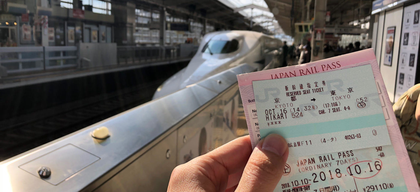 Holding a Japan Rail Pass on a Shinkansen platform