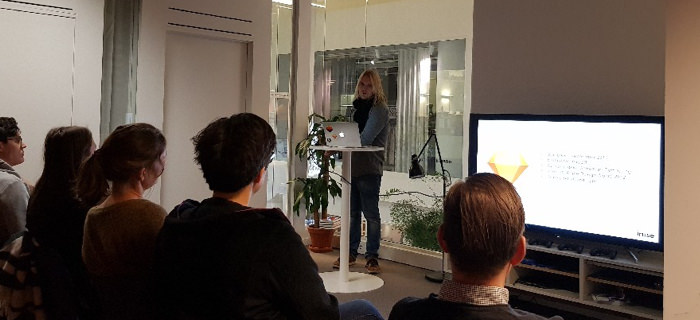 Alexander in front of an audience giving a talk