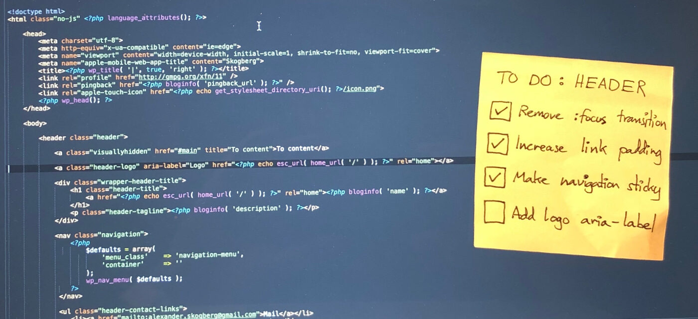 Code shown on a monitor with a post-it note with a to do list stuck to it