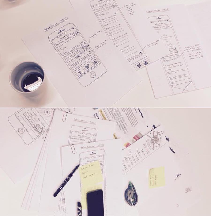 Lots of paper wireframes and some notes on a table