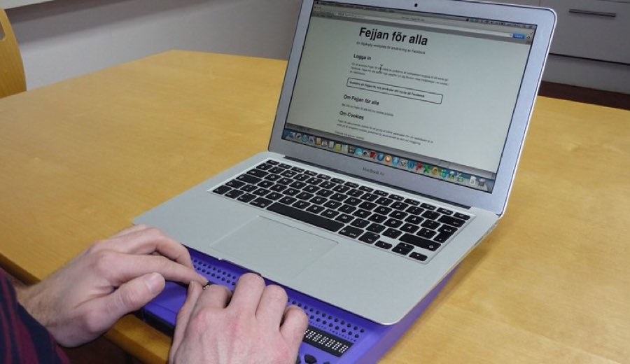 A user browsing Fejjan För Alla on a laptop using a Braille keyboard.